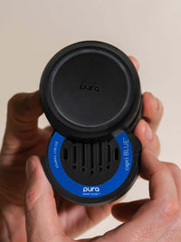 Person inserting Volcano car fragrance into a Pura car diffuser
