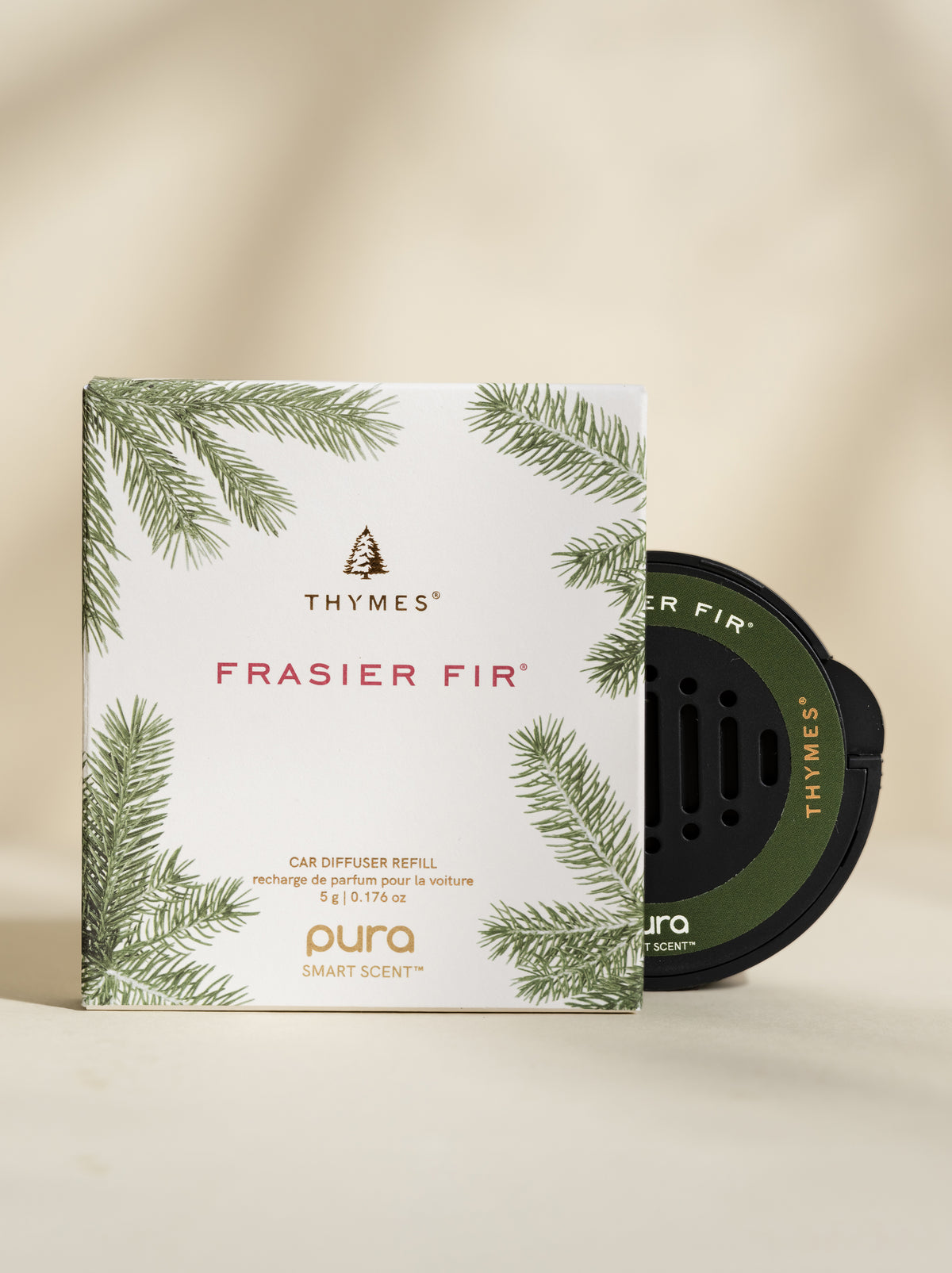 Thymes Frasier Fir car fragrance and packaging on a beige background