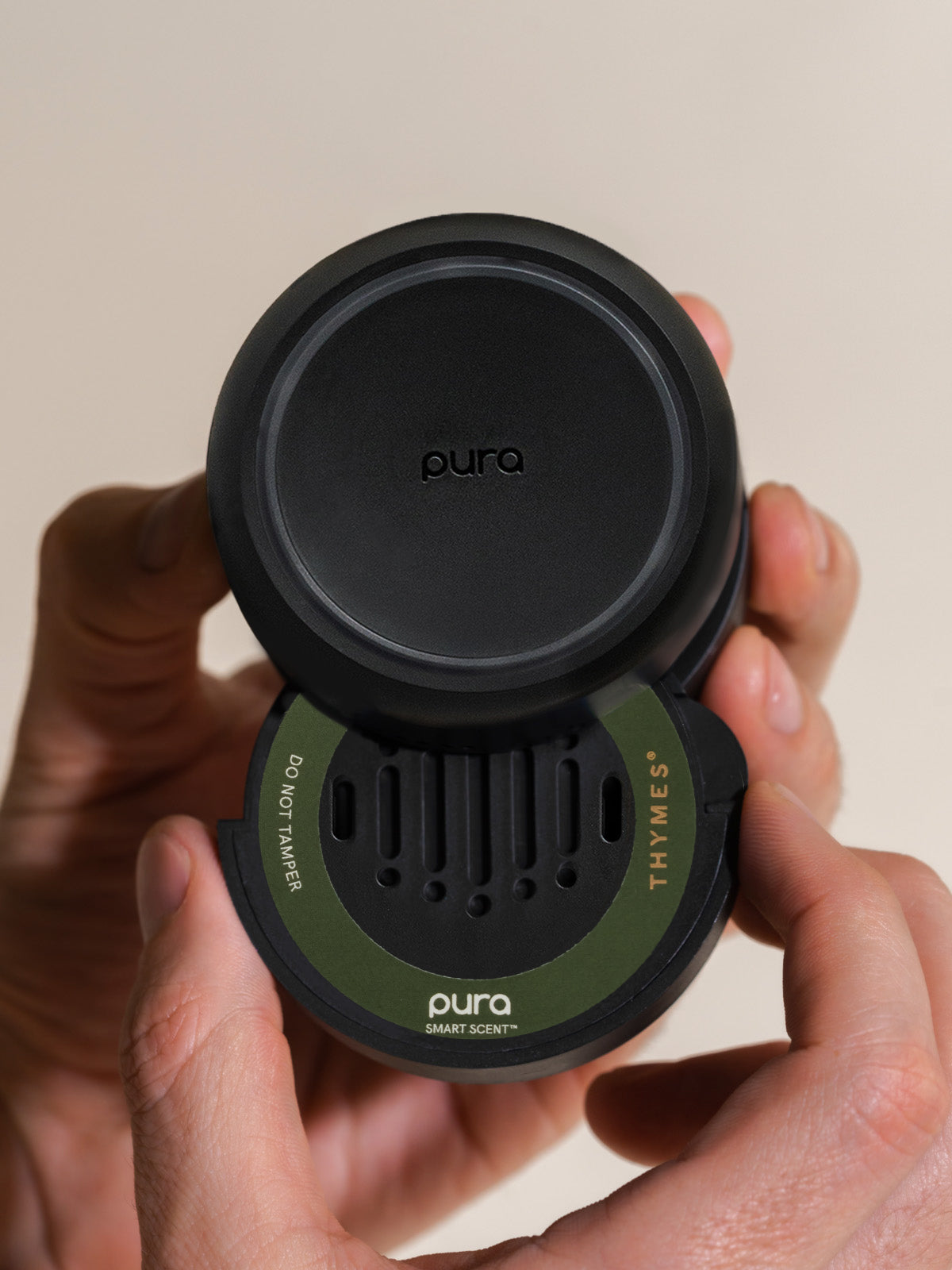 Person inserting a Frasier Fir car fragrance into a Pura car diffuser