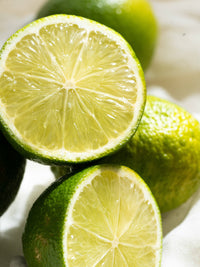 Close-up of sliced limes on a white surface